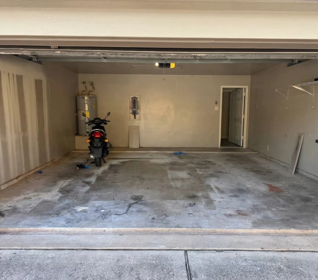 Worn concrete garage floor before epoxy coating