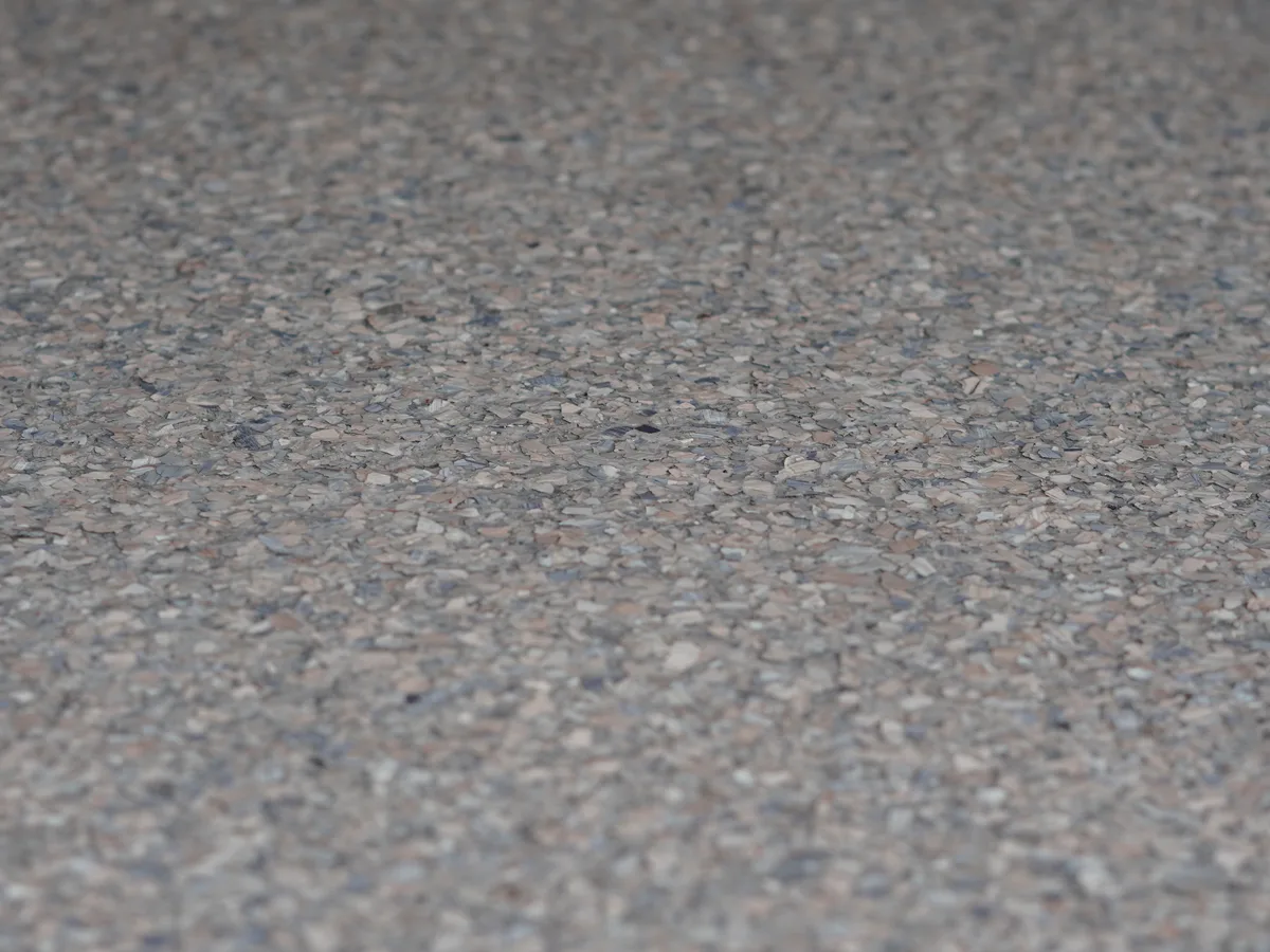 Polyaspartic topcoat being applied over epoxy base on a Houston garage floor