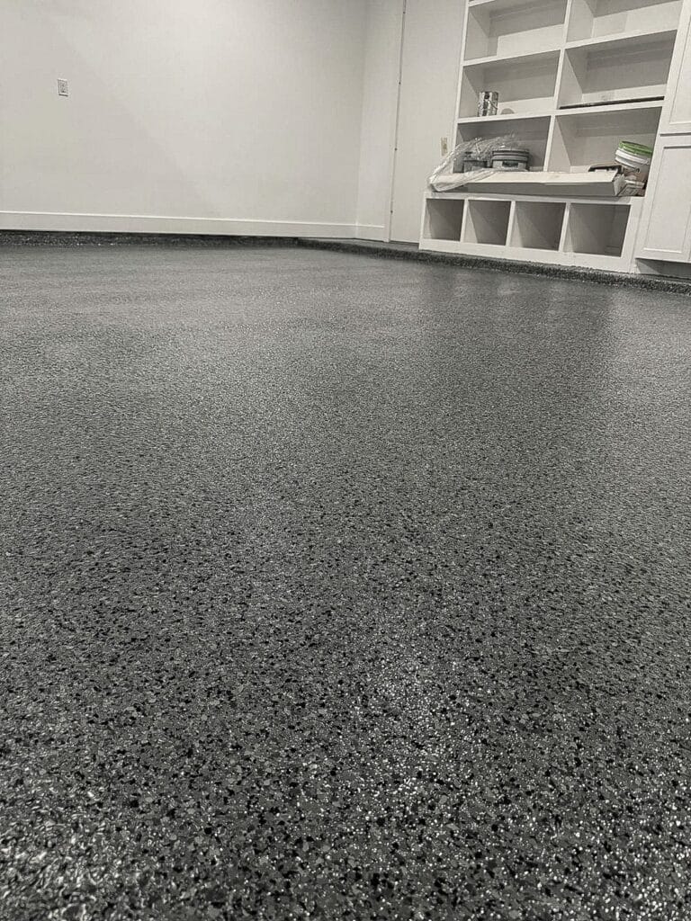 Speckled flake garage floor with built-in white shelving