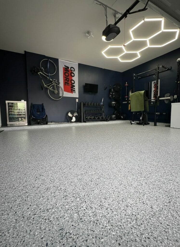 Speckled flake floor in a home gym under hexagon lights