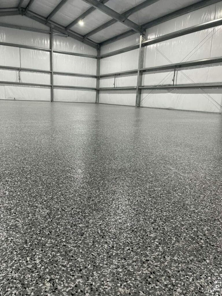 Gray speckled flake floor in a large metal building garage